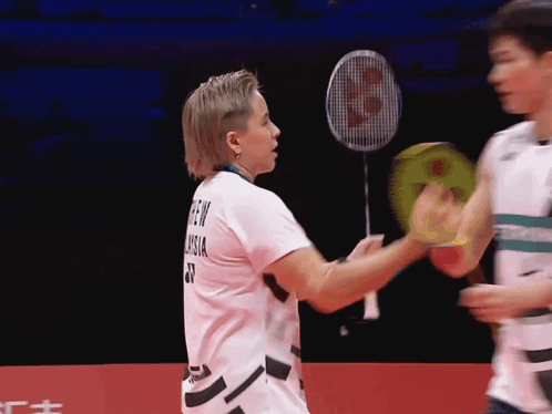A Badminton Player Wearing A Shirt That Says ' Green Vision ' On The Back GIF