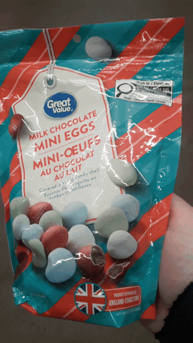 A Bag Of Milk Chocolate Mini Eggs Is Being Held In Someone 'S Hand GIF