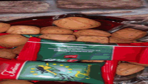 A Bag Of Tortina Cookies Sits Next To A Bowl Of Cookies GIF