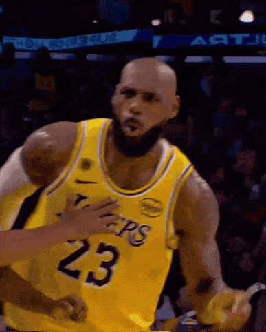 a bald basketball player wearing a yellow jersey with the number 23 on it