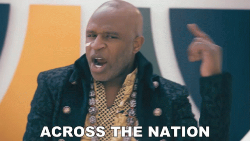 A Bald Man In A Black Jacket And Gold Necklace Says " Across The Nation " GIF