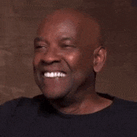 A Bald Man In A Black Shirt Is Laughing And Smiling . GIF