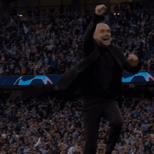 A Bald Man In A Black Suit Is Dancing In Front Of A Crowd GIF
