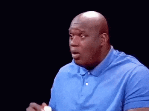 A Bald Man In A Blue Shirt Is Holding A Bottle Of Milk In His Hand . GIF