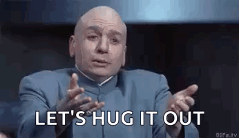 A Bald Man In A Blue Suit Is Making A Funny Face And Says `` Let 'S Hug It Out '' . GIF