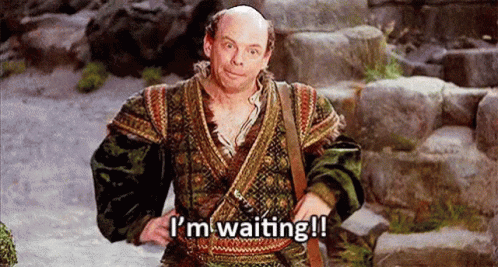 A Bald Man In A Costume Is Standing On A Set Of Stairs . GIF