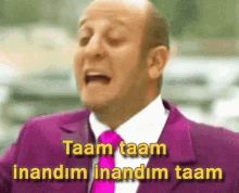 A Bald Man In A Purple Suit And Tie Says Taam Taam Inandim Inandim Taam GIF
