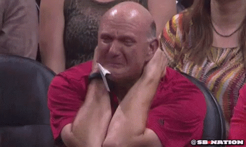 a bald man in a red shirt is crying in a stadium .