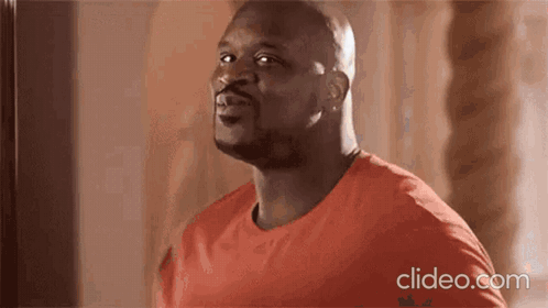 A Bald Man In A Red Shirt Is Looking Up At The Sky . GIF