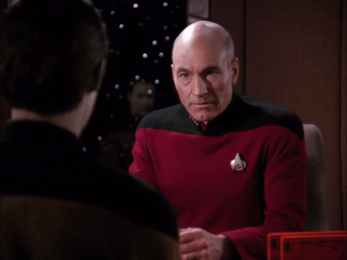 A Bald Man In A Red Shirt Wipes His Face With His Hands GIF