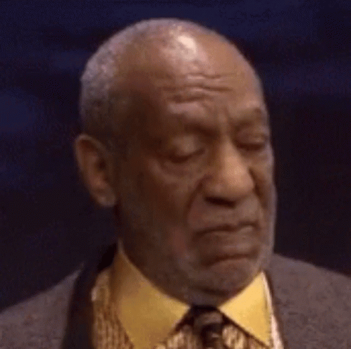 A Bald Man In A Suit And Tie Is Making A Face . GIF