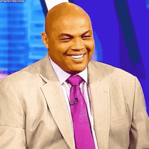 a bald man in a suit and tie is smiling with his eyes closed