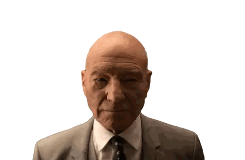 a bald man in a suit and tie looks at the camera with a white background