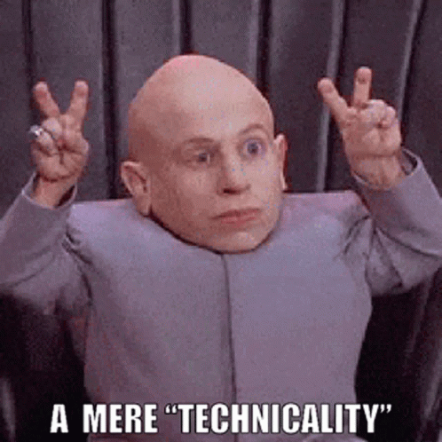 A Bald Man In A Suit Is Making A Peace Sign With His Hands While Sitting In A Chair . GIF