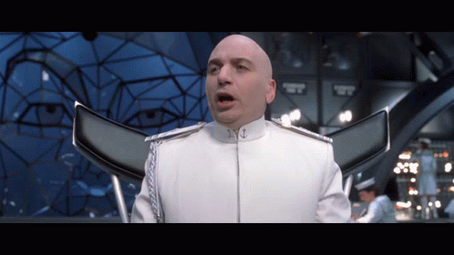 A Bald Man In A White Uniform Has His Mouth Open In A Room GIF