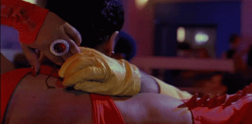 A Bald Man In A Yellow Shirt Is Being Hugged By A Woman GIF