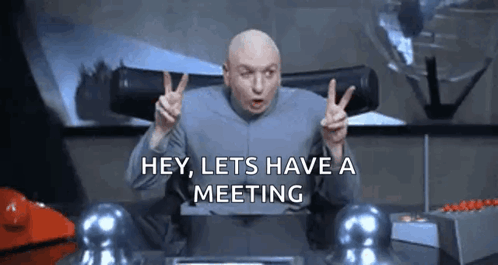 A Bald Man Is Giving A Peace Sign And Saying `` Hey , Lets Have A Meeting '' GIF