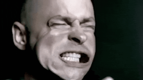 A Bald Man Is Making A Funny Face With His Eyes Closed . GIF