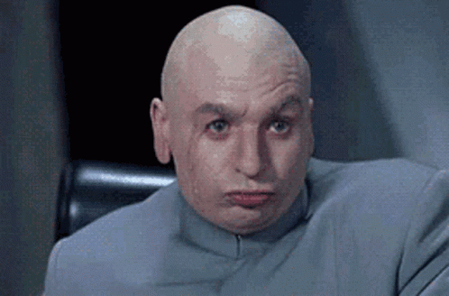 A Bald Man Is Sitting In A Chair With His Eyes Closed . GIF