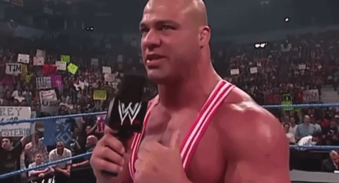A Bald Man Is Standing In A Boxing Ring With His Arms Outstretched . GIF