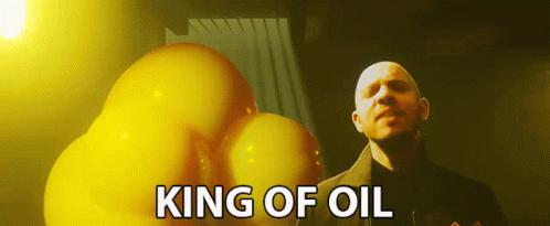 A Bald Man Is Standing In Front Of A Bunch Of Yellow Balloons With The Words King Of Oil Above Him GIF