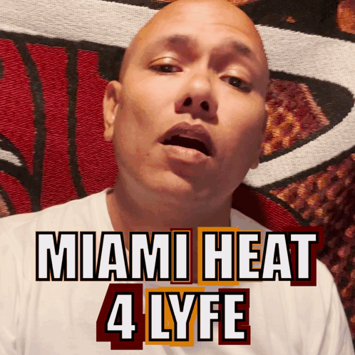 A Bald Man Is Wearing A White Shirt With The Words Miami Heat 4 Lyfe On It GIF