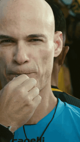 A Bald Man Wearing A Blue Shirt That Says Fadeli On It GIF