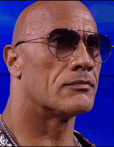 A Bald Man Wearing A Pair Of Sunglasses Looks At The Camera GIF