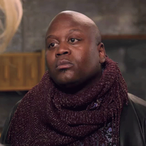 A Bald Man Wearing A Scarf And A Jacket GIF