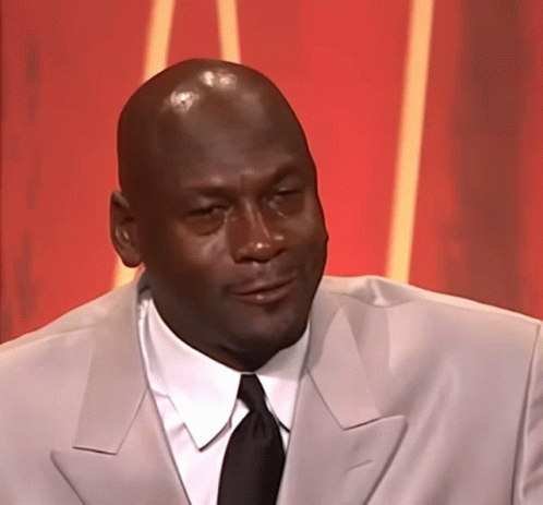 A Bald Man Wearing A Suit And Tie Looks To The Side GIF