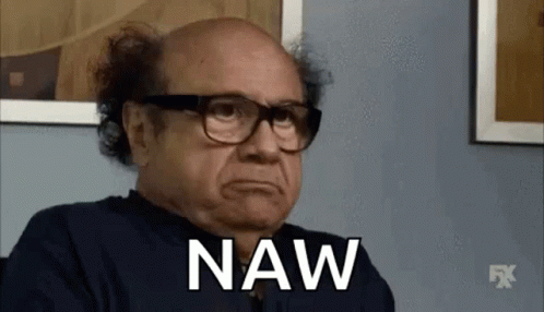 A Bald Man Wearing Glasses And A Black Shirt Is Sitting In Front Of A Wall And Saying Naw . GIF