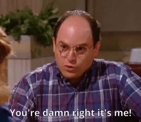 A Bald Man Wearing Glasses And A Plaid Shirt Is Talking To A Woman . GIF