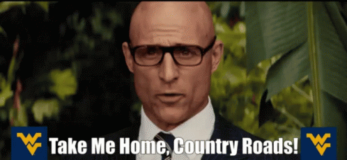 A Bald Man Wearing Glasses And A Suit Says Take Me Home Country Roads GIF