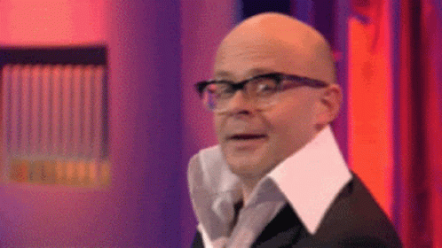 A Bald Man Wearing Glasses And A White Collar Is Making A Funny Face . GIF