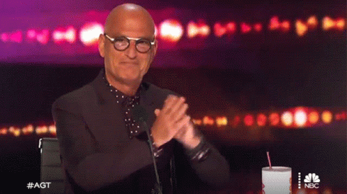 Bald Man With Glasses Applauding In Front Of Microphone GIF
