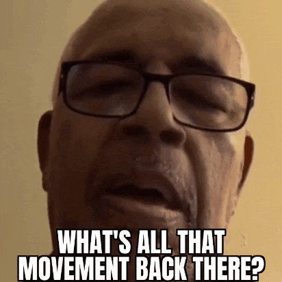 A Bald Man Wearing Glasses Is Asking What 'S All That Movement Back There . GIF