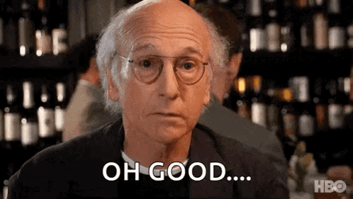 A Bald Man Wearing Glasses Is Sitting At A Table In Front Of A Bar And Saying `` Oh Good ... '' . GIF