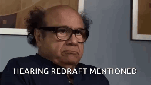 A Bald Man Wearing Glasses Is Sitting In Front Of A Wall And Says `` Hearing Redraft Mentioned '' . GIF