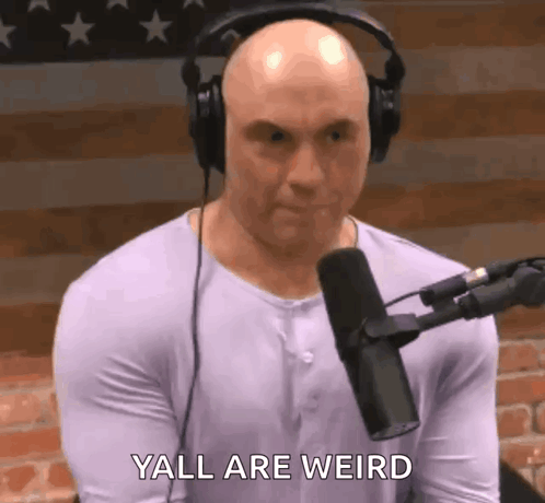A Bald Man Wearing Headphones Is Talking Into A Microphone . GIF