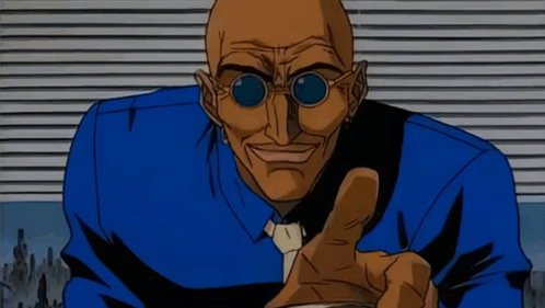 A Bald Man Wearing Sunglasses And A Blue Shirt Is Pointing His Finger GIF