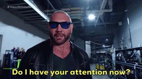 A Bald Man Wearing Sunglasses And A Leather Jacket Says " Do I Have Your Attention Now " GIF