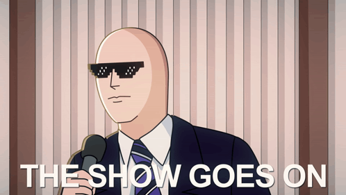 A Bald Man Wearing Sunglasses Is Holding A Microphone And The Show Goes On Is Written Below Him GIF