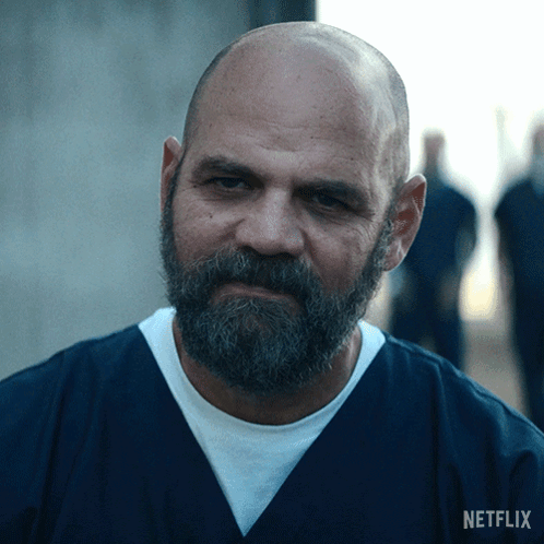 A Bald Man With A Beard And A Netflix Logo On His Shirt GIF