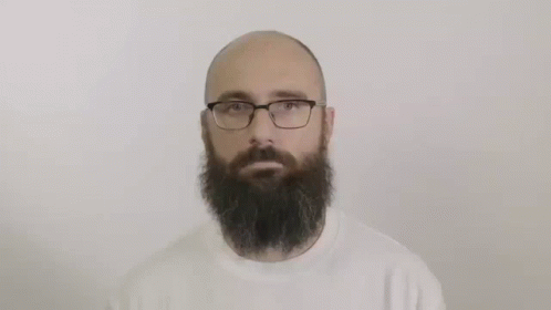 A Bald Man With A Beard And Glasses Is Wearing A White Sweater . GIF