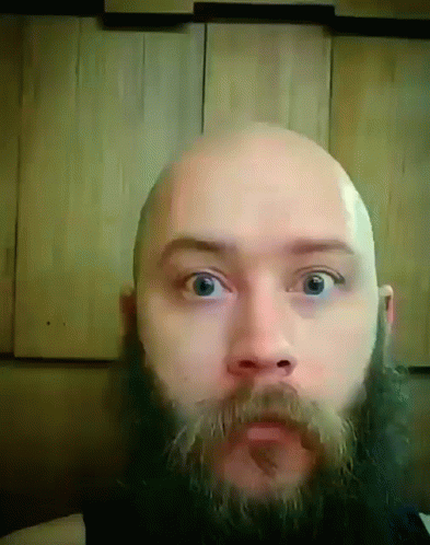 A Bald Man With A Beard And Mustache Is Looking At The Camera GIF