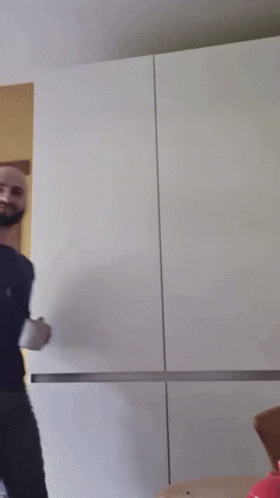 A Bald Man With A Beard Is Holding A Cup GIF
