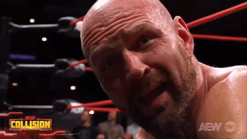 A Bald Man With A Beard Is In A Wrestling Ring With The Aew Collision Logo Behind Him GIF