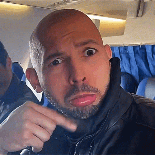 A Bald Man With A Beard Is Pointing To The Camera GIF
