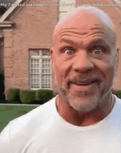 A Bald Man With A Beard Is Smiling In Front Of A Brick House GIF