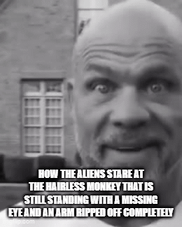 A Bald Man With A Beard Is Standing In Front Of A Building GIF